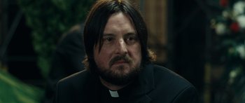 Movie still from “Synecdoche, New York” (2008), directed by Charlie Kaufman – A man with long hair wearing a priest's outfit; Close Up shot, Over the shoulder angle