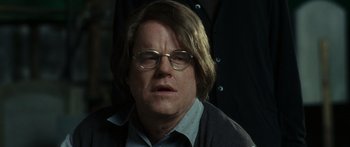 Movie still from “Synecdoche, New York” (2008), directed by Charlie Kaufman – A person wearing glasses and a sweater; Close Up shot, Over the shoulder angle