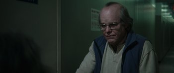 Movie still from “Synecdoche, New York” (2008), directed by Charlie Kaufman – An older man wearing glasses looking at the camera; Close Up shot, Over the shoulder angle