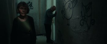 Movie still from “Synecdoche, New York” (2008), directed by Charlie Kaufman – A man leaning against a wall in a dark room; Medium shot, Low angle