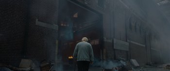 Movie still from “Synecdoche, New York” (2008), directed by Charlie Kaufman – An old man is standing in front of a fire; Wide shot, High angle