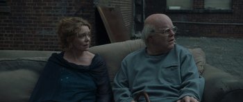 Movie still from “Synecdoche, New York” (2008), directed by Charlie Kaufman – A man and a woman sitting next to each other on a couch; Medium shot, Over the shoulder angle