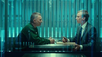 Movie still from “T2 Trainspotting” (2017), directed by Danny Boyle – Two people sitting at a table in front of each other; Medium shot, Over the shoulder angle