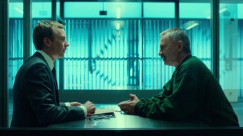 Movie still from “T2 Trainspotting” (2017), directed by Danny Boyle – Two men sitting at a table in front of each other; Medium shot, Over the shoulder angle