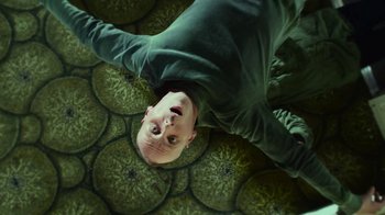 Movie still from “T2 Trainspotting” (2017), directed by Danny Boyle – A man laying on the ground with his head upside down; Medium shot, Overhead angle