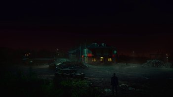 Movie still from “T2 Trainspotting” (2017), directed by Danny Boyle – A man standing in front of a building at night; Extreme Wide shot, Low angle