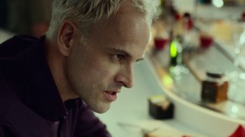 Movie still from “T2 Trainspotting” (2017), directed by Danny Boyle – A person sitting at a table; Close Up shot, Over the shoulder angle