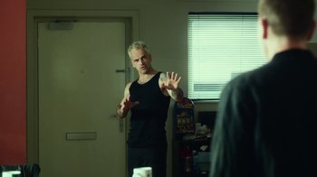 Movie still from “T2 Trainspotting” (2017), directed by Danny Boyle – A man standing in front of a mirror in a room; Medium shot, Over the shoulder angle