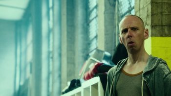 Movie still from “T2 Trainspotting” (2017), directed by Danny Boyle – A bald man standing in front of a window; Close Up shot, Over the shoulder angle