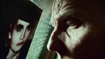 Movie still from “T2 Trainspotting” (2017), directed by Danny Boyle – An older man looking out a window at a picture; Extreme Close Up shot, Low angle