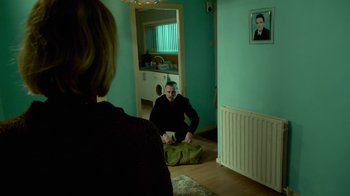 Movie still from “T2 Trainspotting” (2017), directed by Danny Boyle – A man sitting on the floor in front of a woman; Wide shot, High angle
