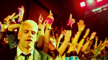 Movie still from “T2 Trainspotting” (2017), directed by Danny Boyle – A crowd of people with their hands in the air at an event; Close Up shot, Low angle