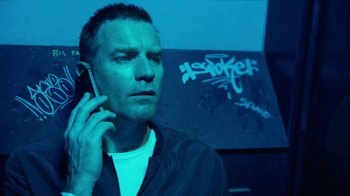 Movie still from “T2 Trainspotting” (2017), directed by Danny Boyle – A man holding a cell phone up to his ear; Close Up shot, Low angle