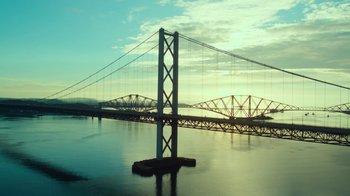 Movie still from “T2 Trainspotting” (2017), directed by Danny Boyle – A large bridge with a large body of water in front of it; Extreme Wide shot, Low angle