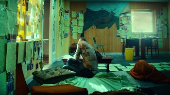 Movie still from “T2 Trainspotting” (2017), directed by Danny Boyle – A man sitting on the floor of a living room; Wide shot, High angle