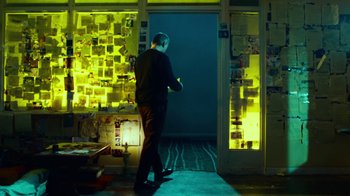 Movie still from “T2 Trainspotting” (2017), directed by Danny Boyle – A man standing in front of an open door in a dark room; Wide shot, Over the shoulder angle