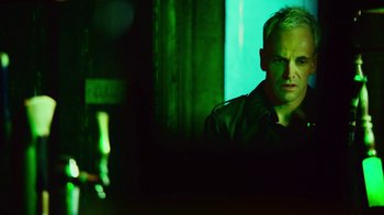 Movie still from “T2 Trainspotting” (2017), directed by Danny Boyle – A man sitting in front of a window in a dark room; Close Up shot, Low angle