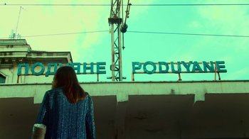 Movie still from “T2 Trainspotting” (2017), directed by Danny Boyle – A woman is standing in front of a building; Wide shot, Low angle