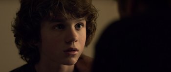 Movie still from “TRON: Legacy” (2010), directed by Joseph Kosinski – A young boy is looking into the distance; Close Up shot, Over the shoulder angle