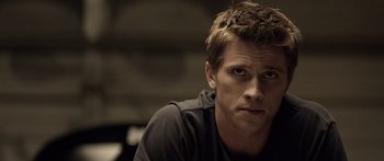 Movie still from “TRON: Legacy” (2010), directed by Joseph Kosinski – A person wearing a black t - shirt; Close Up shot, Over the shoulder angle