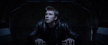Movie still from “TRON: Legacy” (2010), directed by Joseph Kosinski – A man in a leather jacket looking up at the sky; Close Up shot, Low angle