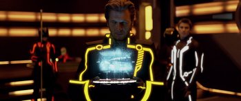 Movie still from “TRON: Legacy” (2010), directed by Joseph Kosinski – A man holding a laptop in front of him; Medium shot, Over the shoulder angle
