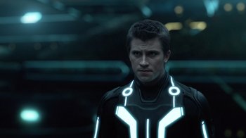 Movie still from “TRON: Legacy” (2010), directed by Joseph Kosinski – A man in a tron costume stands in the dark; Close Up shot, Over the shoulder angle