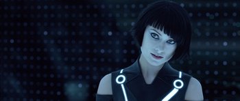 Movie still from “TRON: Legacy” (2010), directed by Joseph Kosinski – A woman in a black outfit with a neon light around her neck; Close Up shot, Over the shoulder angle