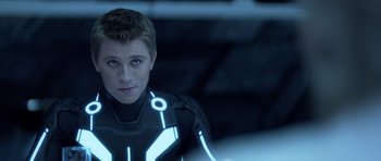 Movie still from “TRON: Legacy” (2010), directed by Joseph Kosinski – A young man in a tron suit looking at the camera; Close Up shot, Over the shoulder angle