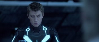 Movie still from “TRON: Legacy” (2010), directed by Joseph Kosinski – A young man in a tron suit looking into the camera; Close Up shot, Over the shoulder angle