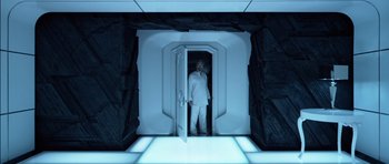 Movie still from “TRON: Legacy” (2010), directed by Joseph Kosinski – A man standing inside of an open door; Wide shot, Overhead angle