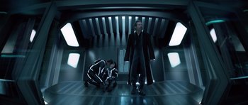 Movie still from “TRON: Legacy” (2010), directed by Joseph Kosinski – Two men in black and white suits in a room; Wide shot, Low angle