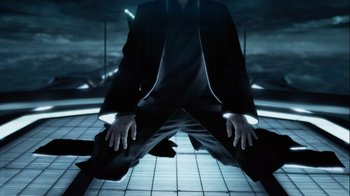 Movie still from “TRON: Legacy” (2010), directed by Joseph Kosinski – A man in a suit is sitting on the ground; Medium shot, High angle