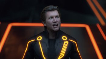 Movie still from “TRON: Legacy” (2010), directed by Joseph Kosinski – A man in a black and yellow suit with neon lights around his neck; Close Up shot, Over the shoulder angle