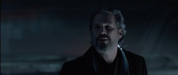 Movie still from “TRON: Legacy” (2010), directed by Joseph Kosinski – A man with long hair and a goatee is wearing a black jacket; Close Up shot, Over the shoulder angle