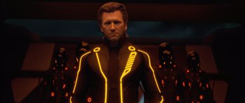 Movie still from “TRON: Legacy” (2010), directed by Joseph Kosinski – A man in a black and yellow suit standing in front of a wall; Medium shot, Low angle