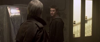 Movie still from “TRON: Legacy” (2010), directed by Joseph Kosinski – A young man looking into a mirror while standing next to an older man; Close Up shot, Over the shoulder angle