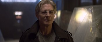 Movie still from “TRON: Legacy” (2010), directed by Joseph Kosinski – An older man wearing glasses and a black jacket; Close Up shot, Over the shoulder angle