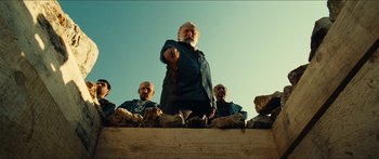 Movie still from “Taken 2” (2012), directed by Olivier Megaton – An old man standing on top of a stone wall; Medium shot, Low angle