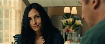 Movie still from “Taken 2” (2012), directed by Olivier Megaton – A woman with long black hair smiling for the camera; Close Up shot, Over the shoulder angle