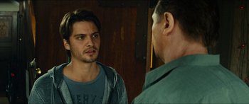 Movie still from “Taken 2” (2012), directed by Olivier Megaton – A man looking into a mirror while standing next to another man; Close Up shot, Over the shoulder angle