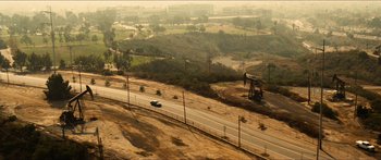 Movie still from “Taken 2” (2012), directed by Olivier Megaton – An aerial view of an oil field with a truck driving down the road; Extreme Wide shot, High angle