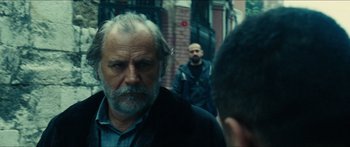 Movie still from “Taken 2” (2012), directed by Olivier Megaton – A man with a gray beard is walking down the street; Close Up shot, Over the shoulder angle