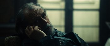 Movie still from “Taken 2” (2012), directed by Olivier Megaton – An older man sitting in a chair with his head resting on his hand; Close Up shot, Over the shoulder angle