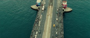 Movie still from “Taken 2” (2012), directed by Olivier Megaton – An aerial view of a bridge with cars driving on it; Extreme Wide shot, Overhead angle