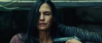Movie still from “Taken 2” (2012), directed by Olivier Megaton – A woman with long black hair is holding a gun; Close Up shot, Low angle