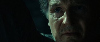 Movie still from “Taken 2” (2012), directed by Olivier Megaton – An older man with a serious look on his face; Close Up shot, Over the shoulder angle