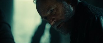 Movie still from “Taken 2” (2012), directed by Olivier Megaton – An old man with a beard looking at the camera; Close Up shot, Over the shoulder angle