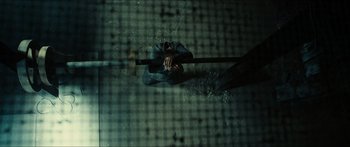 Movie still from “Taken 2” (2012), directed by Olivier Megaton – A person holding a baseball bat in a room; Wide shot, Overhead angle