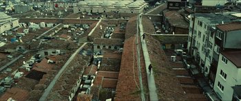 Movie still from “Taken 2” (2012), directed by Olivier Megaton – An aerial view of an old town with a person walking down the sidewalk; Extreme Wide shot, Overhead angle